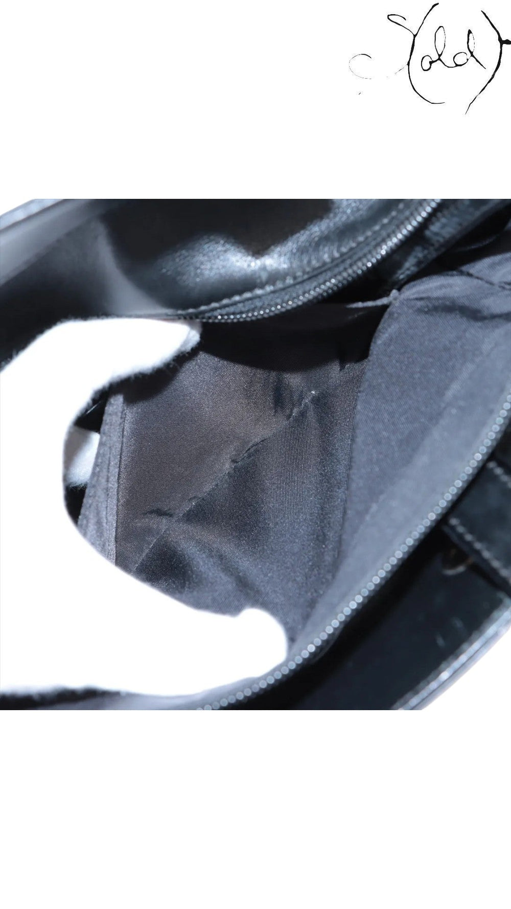 Sold Attire black Chanel Paris-Biarritz PM tote interior with black nylon lining and zipper detail.