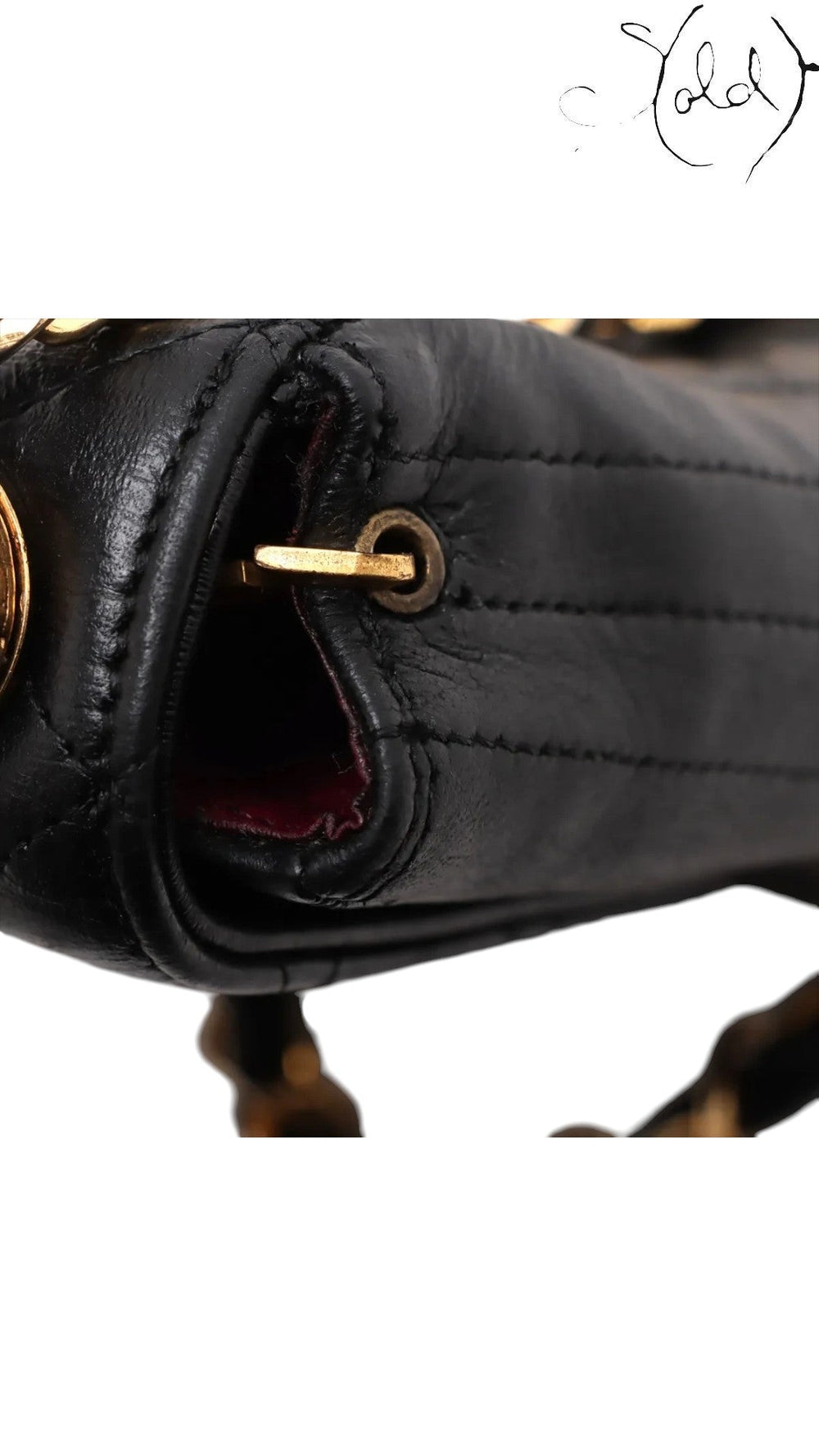 Sold Attire vintage Chanel black quilted lambskin flap bag featuring gold-tone hardware and burgundy leather interior