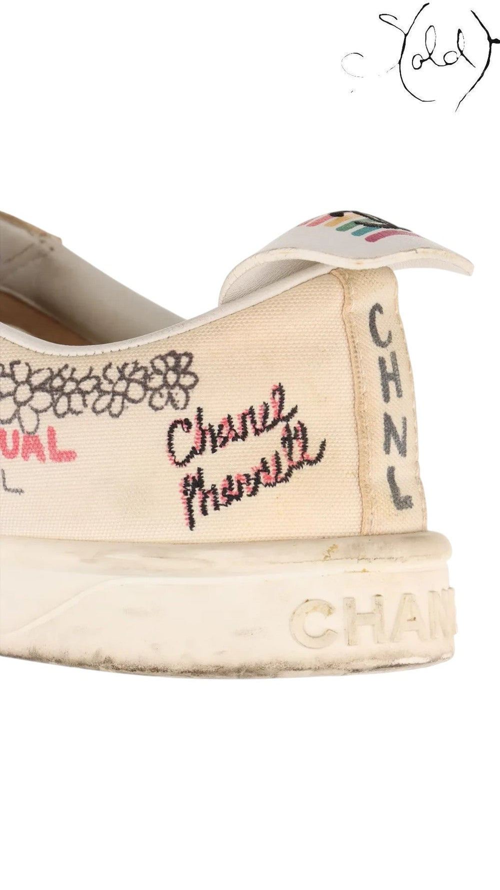 Close-up of a white canvas Chanel x Pharrell sneaker with embroidered Coco Mark and CHNL lettering from Sold Attire.