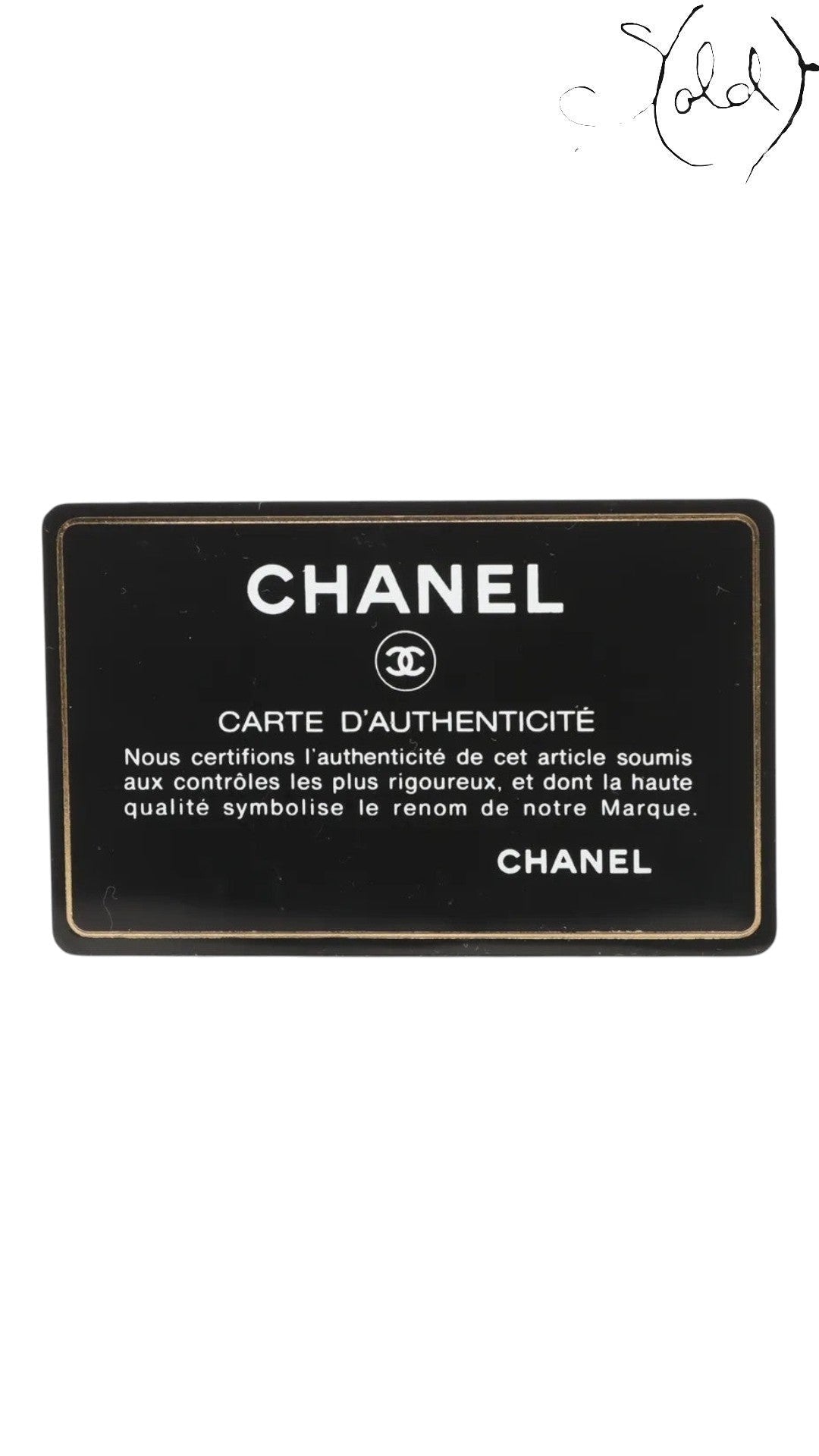Sold Attire Chanel authenticity card, black with gold trim and text. Features Chanel logo and "Carte d'Authenticite" inscription.