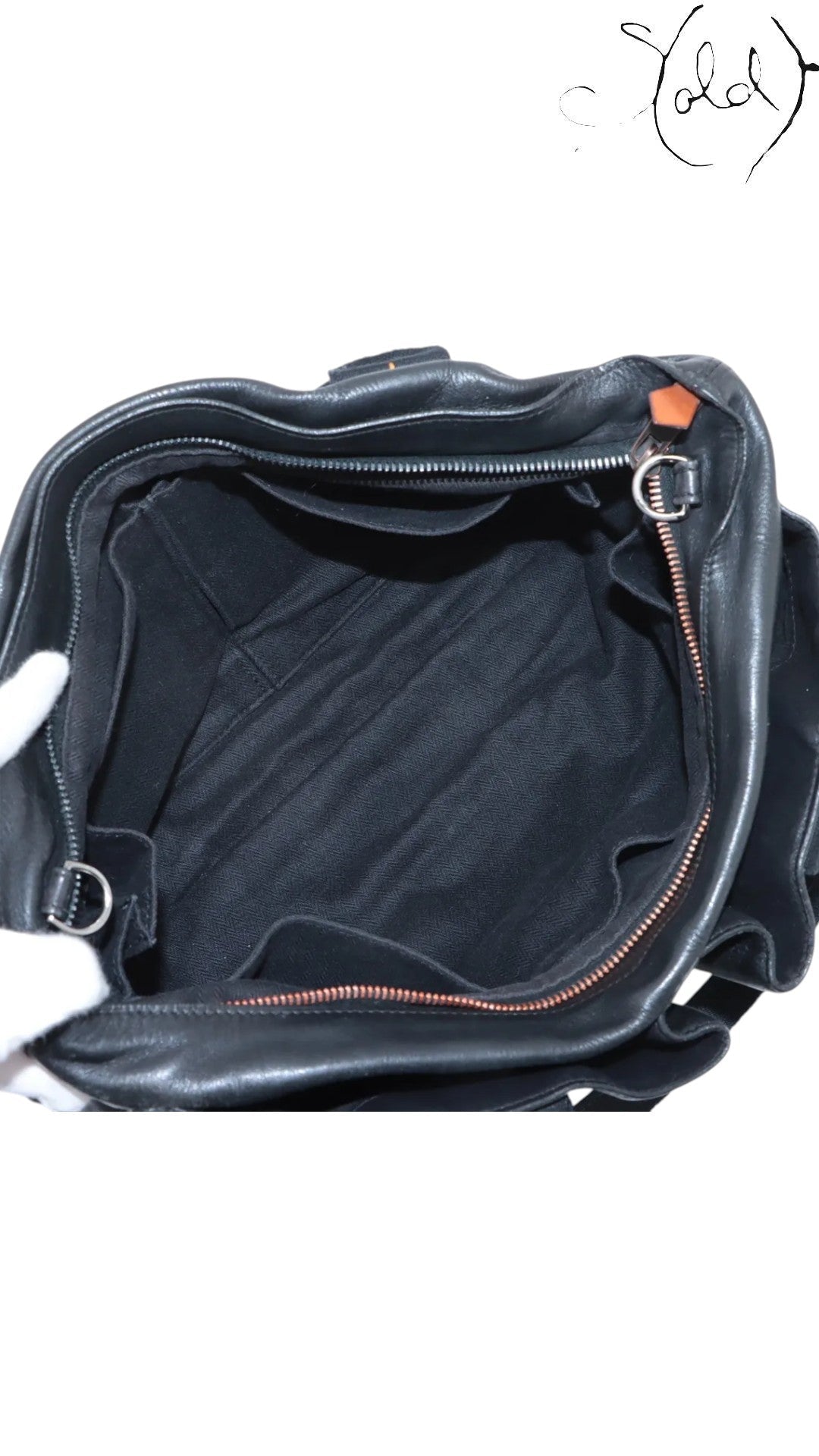 Sold Attire black Veau Derma leather Hermès Caravan Horizontal MM bag with silver hardware, showing interior pockets and herringbone lining.