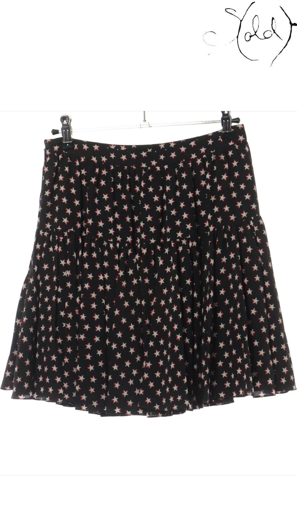 Sold Attire black silk twill mini skirt with a white and red star print, featuring a tiered, pleated design and a concealed back zip.
