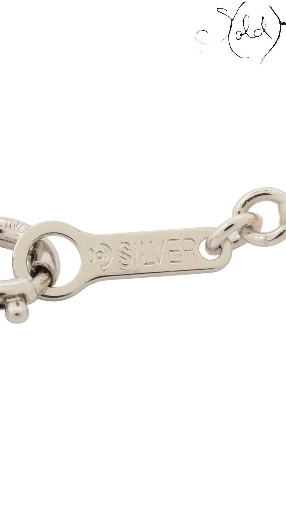 Close-up of the TASAKI pearl necklace silver clasp with hallmark, showing the metal hardware and delicate construction.