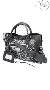 Sold Attire black agneau lambskin Balenciaga Graffiti City Classic Hardware bag with white hand-painted graffiti and a detachable shoulder strap.