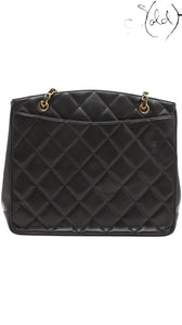 Sold Attire black quilted lambskin matelasse chain tote with gold hardware and open top construction.