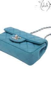 Sold Attire blue quilted caviar leather Chanel Extra Mini Classic Flap bag with silver-tone hardware and chain strap.