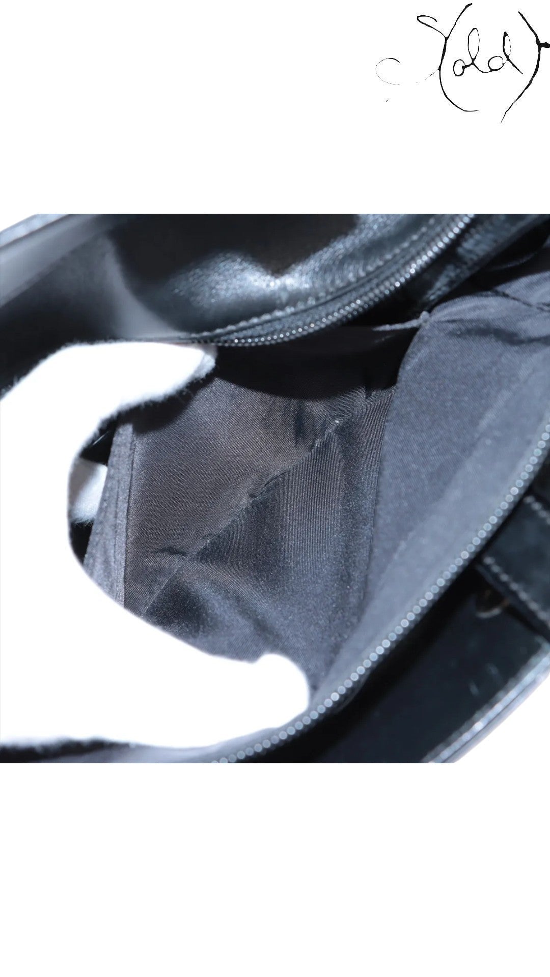 Sold Attire black Chanel Paris-Biarritz PM tote interior with black nylon lining and zipper detail.