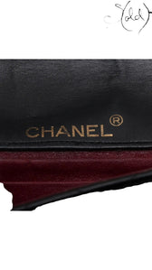 Sold Attire vintage Chanel bag interior featuring gold CHANEL logo stamping on black leather above burgundy lining.