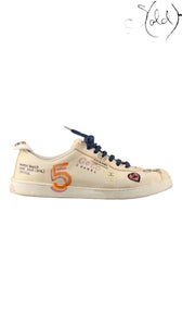 Sold Attire pre-owned Chanel x Pharrell low-top sneakers in white canvas with multicolor graphic COCO print and laces.