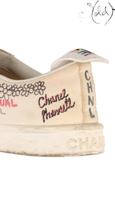 Close-up of a white canvas Chanel x Pharrell sneaker with embroidered Coco Mark and CHNL lettering from Sold Attire.