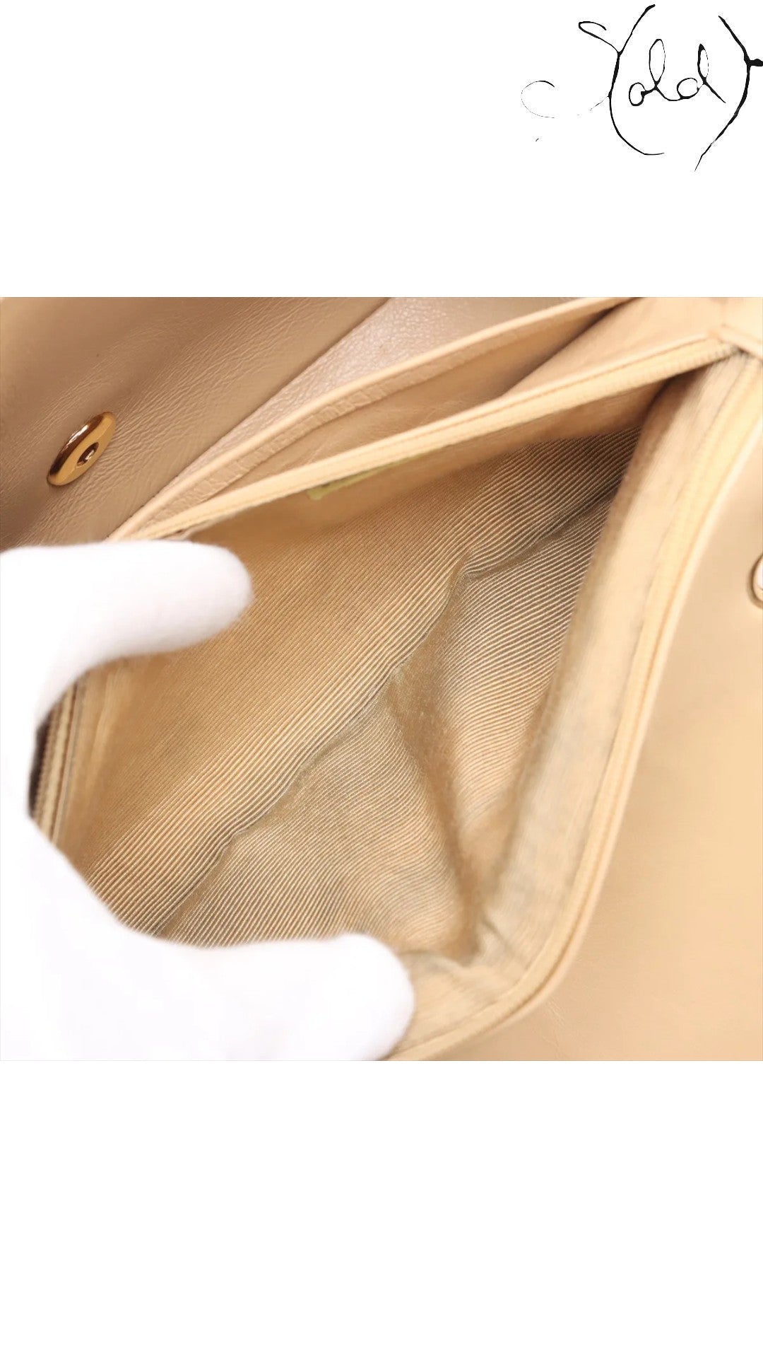 Sold Attire beige lambskin Chanel Diana medium bag interior with gold hardware clasp and striped lining.