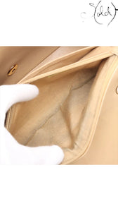 Sold Attire beige lambskin Chanel Diana medium bag interior with gold hardware clasp and striped lining.