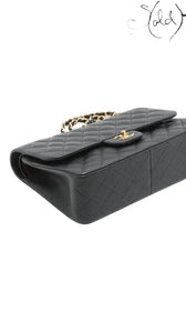 Sold Attire black caviar leather Chanel Jumbo Classic Double Flap bag with gold hardware and chain strap.