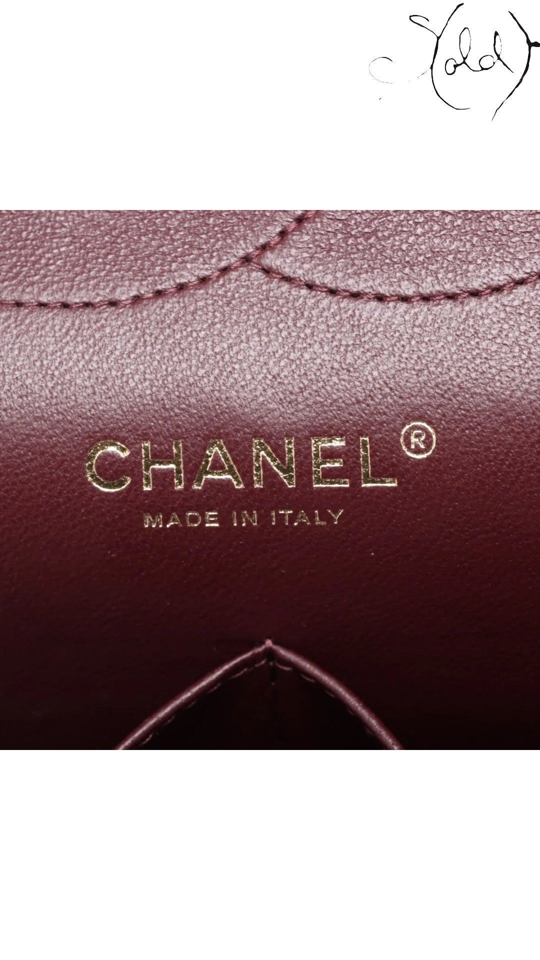 Sold Attire black caviar leather Chanel Jumbo Classic Double Flap bag interior with gold hardware logo and burgundy lining.