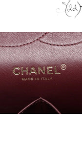 Sold Attire black caviar leather Chanel Jumbo Classic Double Flap bag interior with gold hardware logo and burgundy lining.