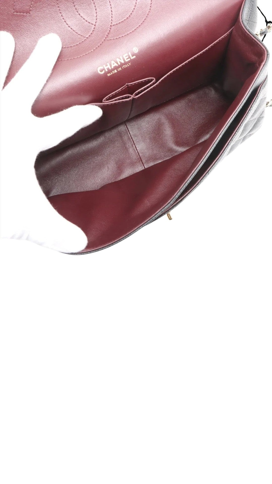 Sold Attire black caviar leather Chanel Jumbo Classic Double Flap bag with burgundy interior and gold hardware.