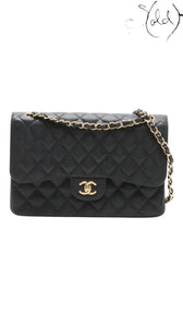 Sold Attire black caviar leather Chanel Jumbo Classic Double Flap bag with gold hardware and chain strap.