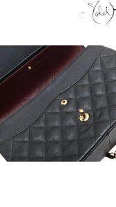 Sold Attire black caviar leather Chanel Jumbo Classic Double Flap bag with gold hardware and burgundy lining.