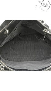 Sold Attire black quilted caviar leather Chanel CC tote with silver-tone hardware and striped lining.