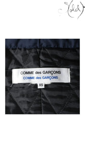 Sold Attire navy polyester padded cape coat from Comme des Garçons AW16 collection, size XS. Features quilted lining and signature branding.