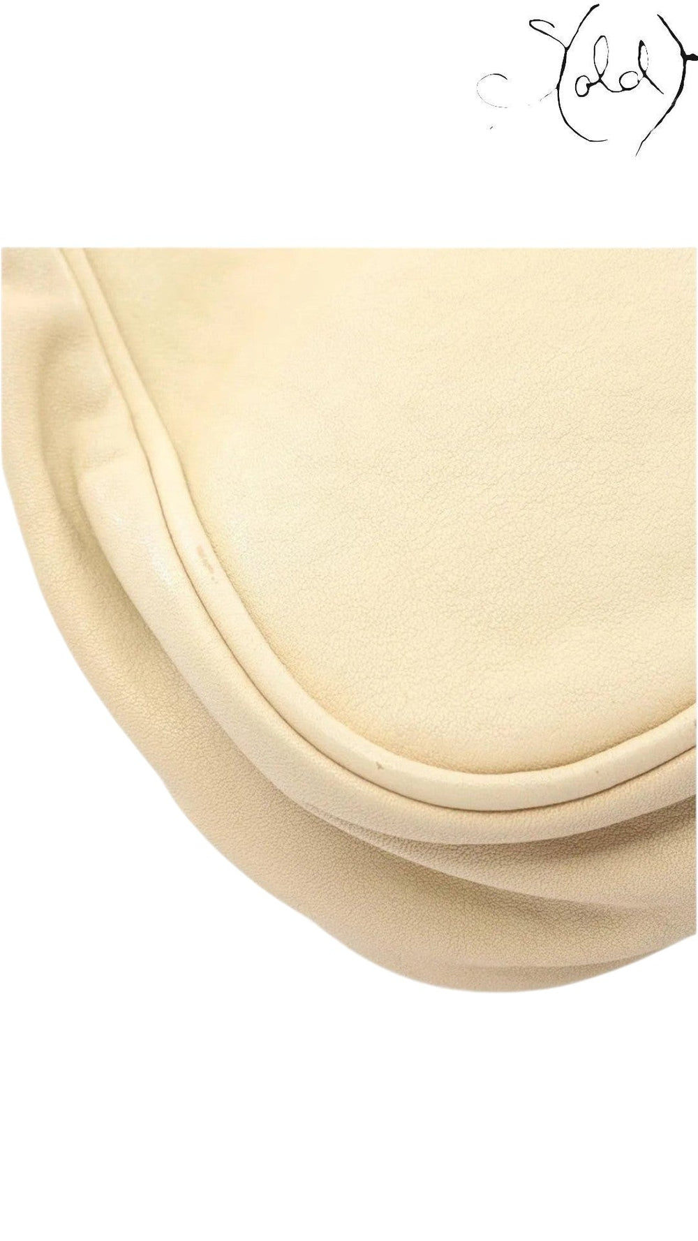 Close-up of the beige calf leather texture and curved flap edge of a vintage Sold Attire Dior Gaucho shoulder bag