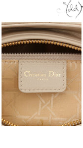 Sold Attire interior view of a Dior Lady Dior handbag showing the ivory leather brand tag with gold logo embossing.