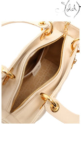 Sold Attire ivory Lady Dior handbag interior showing quilted Cannage leather, gold-tone hardware, and Dior branding.