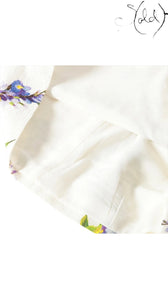 Sold Attire white sleeveless dress with a vibrant wisteria floral print and a black and white striped bodice. Cotton-polyurethane blend.