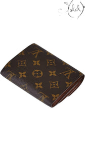 Sold Attire Louis Vuitton Joey wallet in brown Monogram coated canvas with a compact folded design.