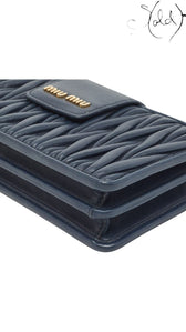 Sold Attire navy blue matelasse leather Miu Miu phone bag with gold tone logo.