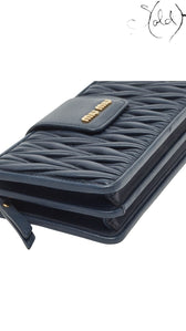 Sold Attire navy blue matelasse leather Miu Miu phone bag with gold tone logo detail.