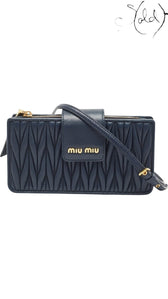 Sold Attire navy matelasse leather Miu Miu phone bag with gold hardware and chain strap.