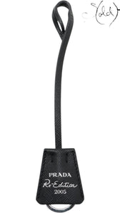 Sold Attire black Saffiano leather Prada Re-Edition 2005 bag charm with silver ring.