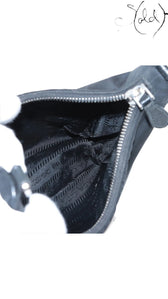 Sold Attire black Prada Re-Edition 2005 nylon shoulder bag with Saffiano leather trim and silver hardware.