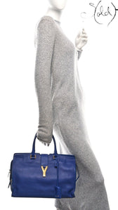 Sold Attire model carrying a royal blue Saint Laurent Medium Classic Y Cabas tote with gold hardware.