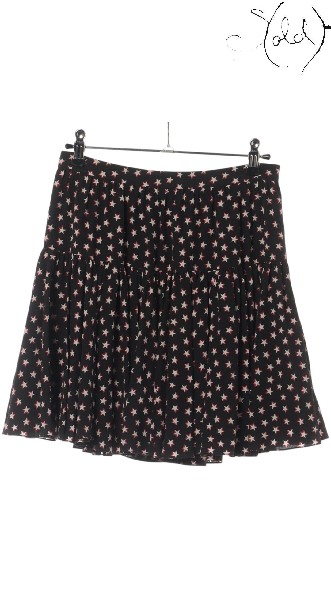 Sold Attire black silk twill mini skirt with a repeating white and red star print, featuring a tiered, gathered hem and a concealed back zipper.