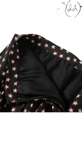 Sold Attire black silk twill mini skirt with a white and red star print, featuring a concealed back zipper and smooth black lining.