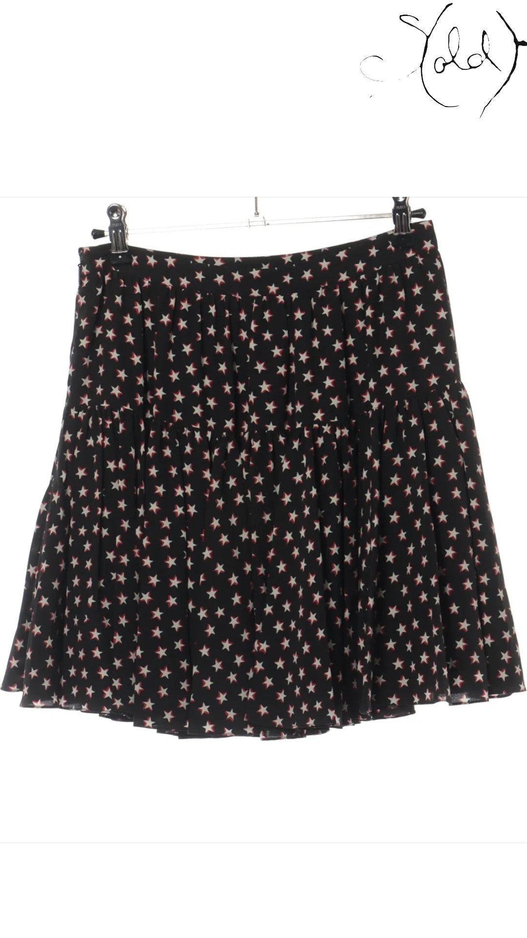 Sold Attire black silk twill mini skirt with a white and red star print, featuring a tiered, pleated design and a concealed back zip.