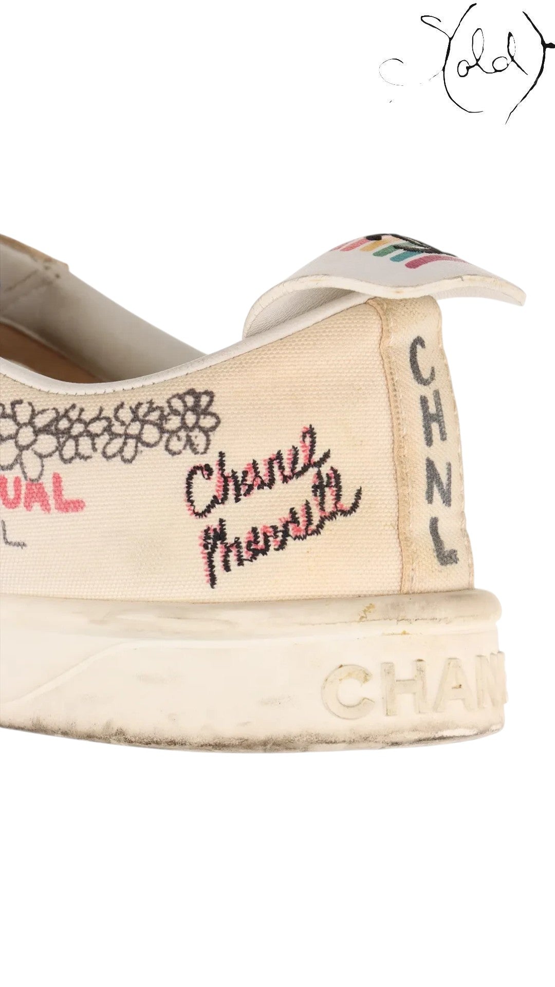 Close-up of a white canvas Chanel x Pharrell sneaker with embroidered Coco Mark and CHNL lettering from Sold Attire.