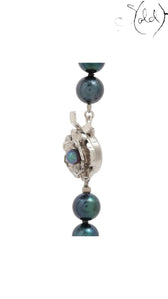 Sold Attire dark green-blue Akoya pearl necklace featuring a detailed silver floral clasp with a central pearl accent.