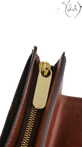 Sold Attire Louis Vuitton Joey wallet featuring a gold-tone zipper pull with engraved logo and brown leather interior