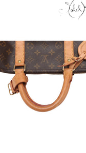 Sold Attire Louis Vuitton Keepall 55 travel bag featuring brown Monogram coated canvas and natural cowhide leather handles.